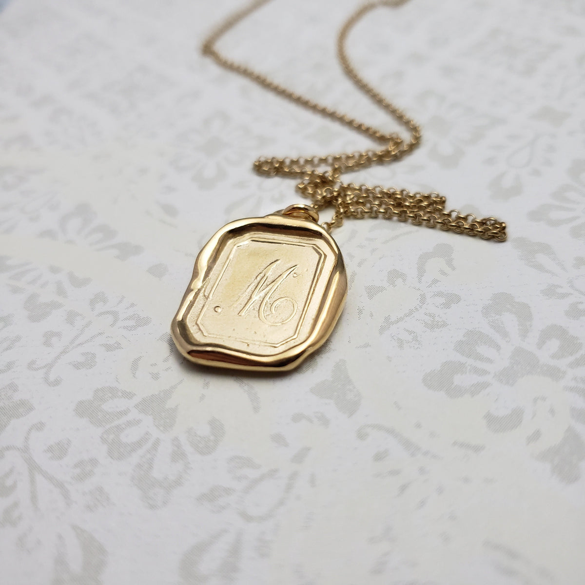 Letter M in gold vermeil